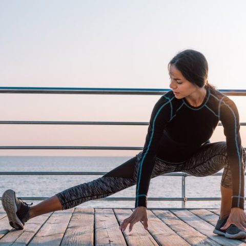 young-athletic-girl-performs-squats-on-wooden-embankment-by-the-sea-in-early-morning-healthy_t20_G0roPw