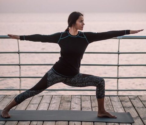 young-brunette-woman-doing-yoga-exercises-on-wooden-sea-embankment-in-the-morning-girl-in-black_t20_YEA4aE